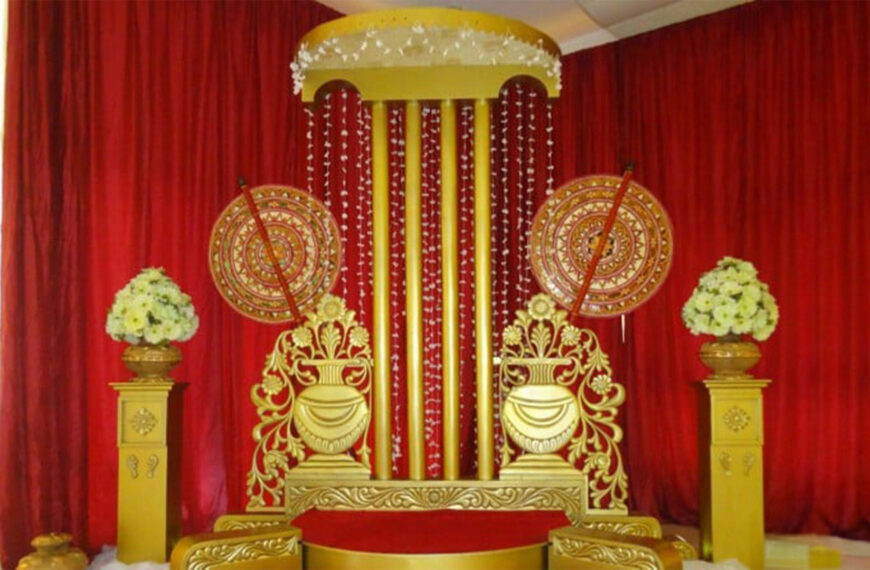 Ornate Sri Lankan wedding ceremonial stage with a gold domed canopy, red curtains, floral arrangements, and intricate patterns, featured on Poruwa.lk | ශ්‍රී ලාංකීය මංගල යෝජනා, Mangala Yojana, Sri Lanka matrimony, and top marriage proposals.