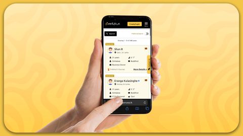 A hand grips a smartphone on a yellow background, highlighting the app's design and functionality, showcasing features for SriLanka matrimony and matrimony Sri Lanka, helping users explore marriage proposals Sri Lanka, and plan for a traditional Poruwa ceremony.