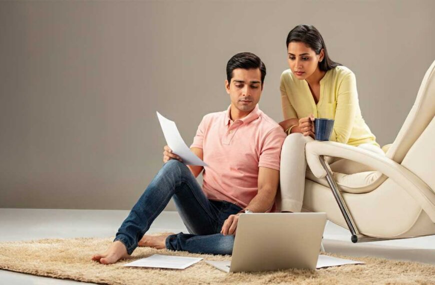 A man and woman sitting on the floor with a laptop, exploring Poruwa.lk | ශ්‍රී ලාංකීය මංගල යෝජනා, SriLanka matrimony, matrimony Sri Lanka, browsing marriage proposals Sri Lanka and learning about Poruwa ceremony traditions.