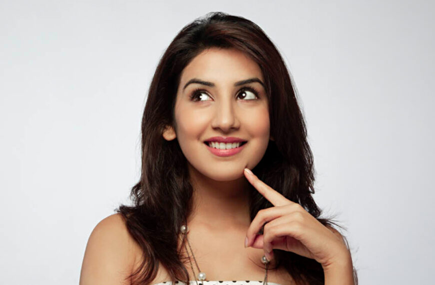A smiling woman resting her chin on her hand, exuding a thoughtful and cheerful demeanor, representing the joyful spirit of SriLanka matrimony and matrimony Sri Lanka, while symbolizing love, marriage proposals Sri Lanka, and the cultural beauty of a Poruwa ceremony.