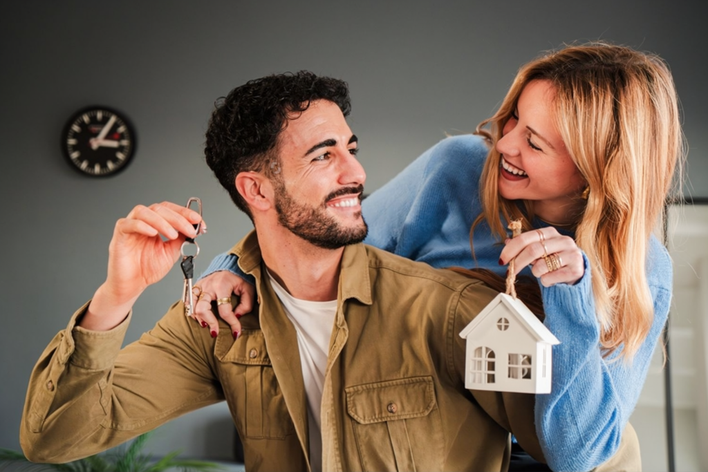 A Sri Lankan couple holding a house key and a model home, symbolizing building a new life together after marriage proposals Sri Lanka and successful mangala yojana. Represents life milestones for lanka brides and grooms through Poruwa.lk | ශ්‍රී ලාංකීය මංගල යෝජනා, a trusted wedding proposal website for matrimony Sri Lanka, srilanka matrimony, buddhist matrimony, catholic marriage proposals, and liyathabara marriage proposals in Sri Lanka