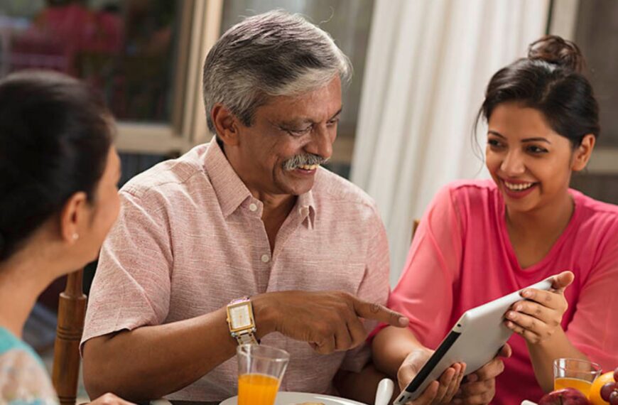 A young South Asian couple discussing marriage proposals in Sri Lanka with an older man using a tablet, exploring options on Poruwa.lk, a trusted Sri Lankan matrimonial website.