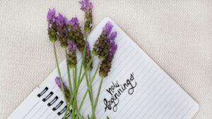 Lavender flowers around a notepad with Happy Birthday written in the center, elegant floral birthday greeting.
