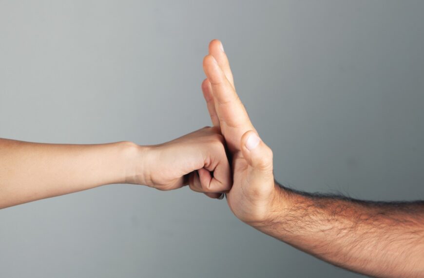 Fist hitting a palm on a gray background, representing conflict, aggression, or violence in Sri Lanka.