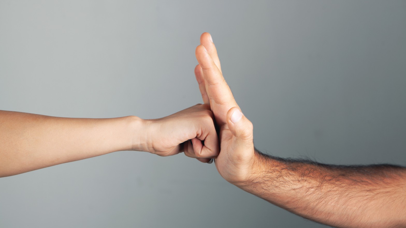 Fist hitting a palm on a gray background representing conflict, aggression, and violence awareness in Sri Lanka, featured on Poruwa.lk | ශ්‍රී ලාංකීය මංගල යෝජනා, a trusted wedding proposal website for marriage proposals in Sri Lanka, matrimony Sri Lanka, Buddhist matrimony, Catholic marriage proposals, Lanka brides and grooms, and liyathabara marriage proposals in Sri Lanka.
