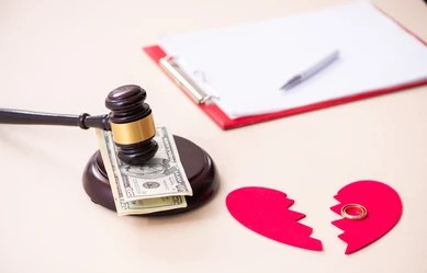 Gavel resting on dollar bills beside a broken paper heart with a ring, symbolizing divorce, legal separation, and relationship challenges, alongside a clipboard and pen in the background, representing legal and matrimonial decisions in Sri Lanka featured on Poruwa.lk | ශ්‍රී ලාංකීය මංගල යෝජනා, a trusted wedding proposal website for mangala yojana, marriage proposals in Sri Lanka, matrimony Sri Lanka, Lanka brides and grooms, Buddhist matrimony, and Catholic marriage proposals.