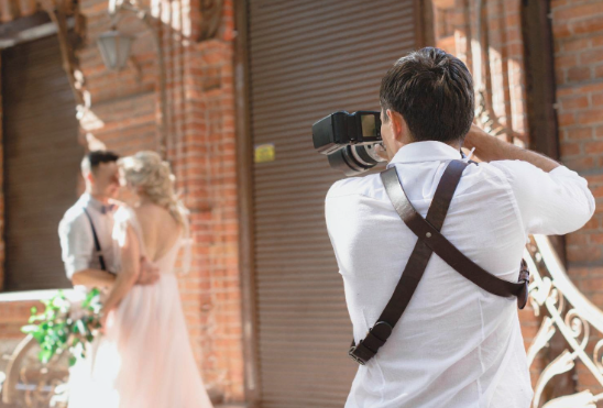 A man photographing a bride and groom during their wedding ceremony, capturing a joyful moment in matrimony Sri Lanka and srilanka matrimony traditions, marriage proposal Sri Lanka, marriage proposals in Sri Lanka, marriage proposals Sri Lanka, mangala yojana, wedding proposal website services, poruwa ceremony celebrations, buddhist matrimony, catholic marriage proposals, Lanka brides and grooms, and platforms like Poruwa.lk | ශ්‍රී ලාංකීය මංගල යෝජනා, along with liyathabara marriage proposal, liyathabara marriage proposals in Sri Lanka, hitad marriage proposals, purahanda lk, and other marriage proposals.