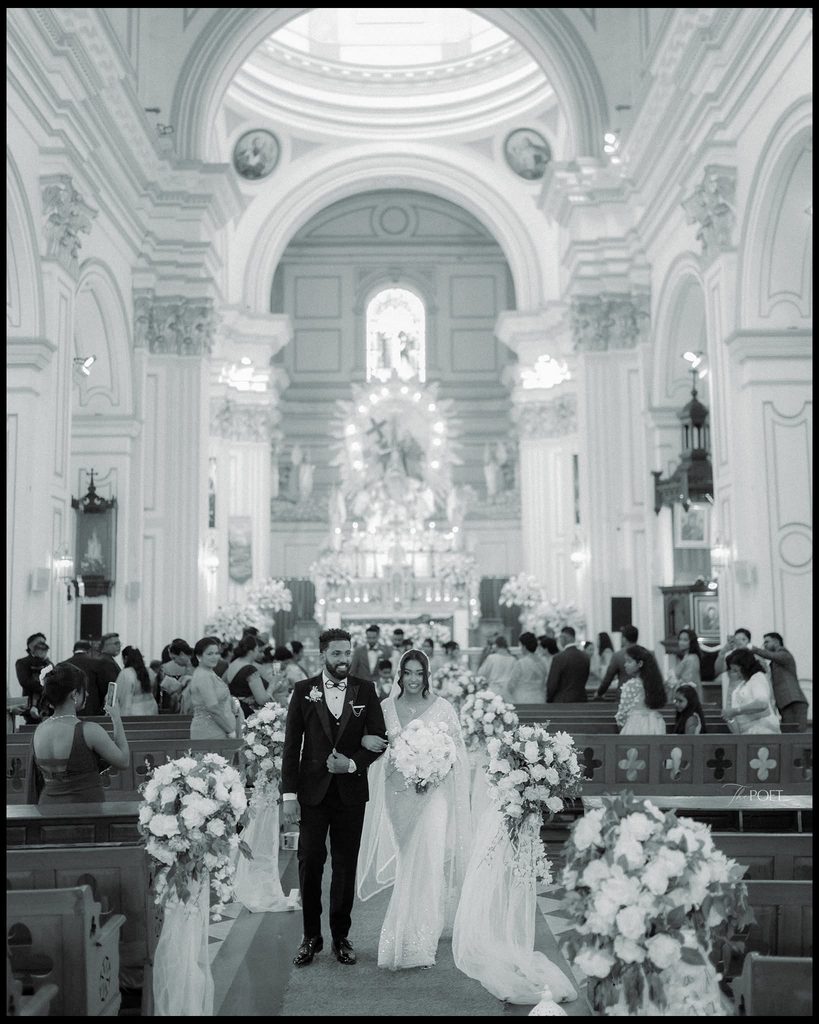 Black and white photo of a bride and groom joyfully walking down the aisle after their wedding ceremony, capturing a memorable Sri Lankan wedding celebration and traditions connected with mangala yojana, marriage proposals in Sri Lanka, matrimony Sri Lanka, srilanka matrimony, lanka brides and grooms, Buddhist matrimony, Catholic marriage proposals, liyathabara marriage proposals in Sri Lanka, and Poruwa.lk | ශ්රී ලාංකීය මංගල යෝජනා.