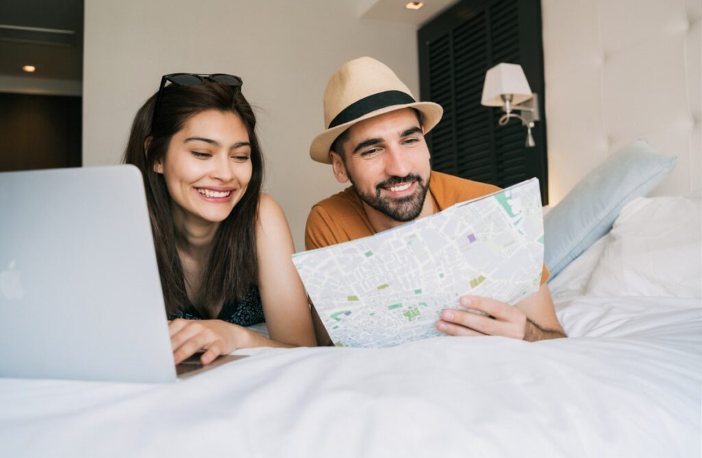A Sri Lankan couple examining a map together while relaxing on a bed, planning their next adventure and sharing a meaningful moment of partnership. Represents love, companionship, and building future dreams together for couples exploring marriage proposals Sri Lanka, mangala yojana, and matrimony Sri Lanka through Poruwa.lk | ශ්‍රී ලාංකීය මංගල යෝජනා, a trusted wedding proposal website for lanka brides and grooms, srilanka matrimony, buddhist matrimony, catholic marriage proposals, and liyathabara marriage proposals in Sri Lanka.
