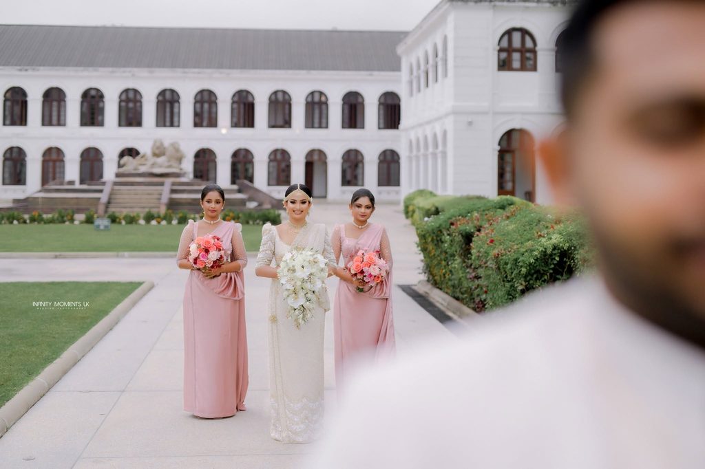 A Sri Lankan bride in a white wedding gown walks with her bridesmaids, capturing a joyful wedding celebration inspired by mangala yojana traditions, marriage proposals in Sri Lanka, matrimony Sri Lanka, srilanka matrimony, lanka brides and grooms, Buddhist matrimony, Catholic marriage proposals, liyathabara marriage proposals in Sri Lanka, and Poruwa.lk | ශ්‍රී ලාංකීය මංගල යෝජනා.