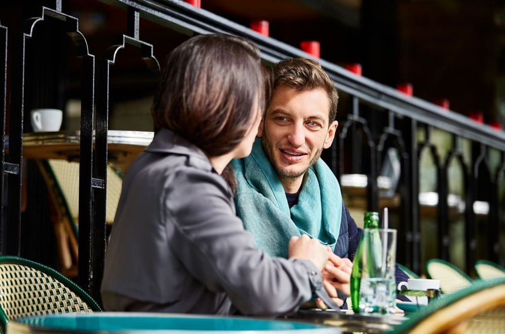 A man and woman seated at an outdoor café, enjoying drinks and conversation under a sunny sky, representing a safe first meeting after connecting through online marriage proposals, matrimony Sri Lanka, and marriage proposals in Sri Lanka.