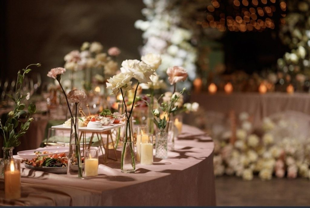 A beautifully arranged table featuring vibrant flowers and flickering candles, creating an inviting atmosphere.